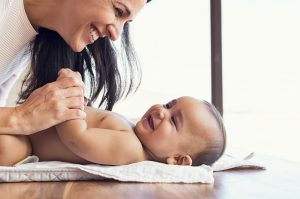 Mother changing diaper to toddler Nanny Full Time